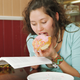 Girl reading and eating a doughnut